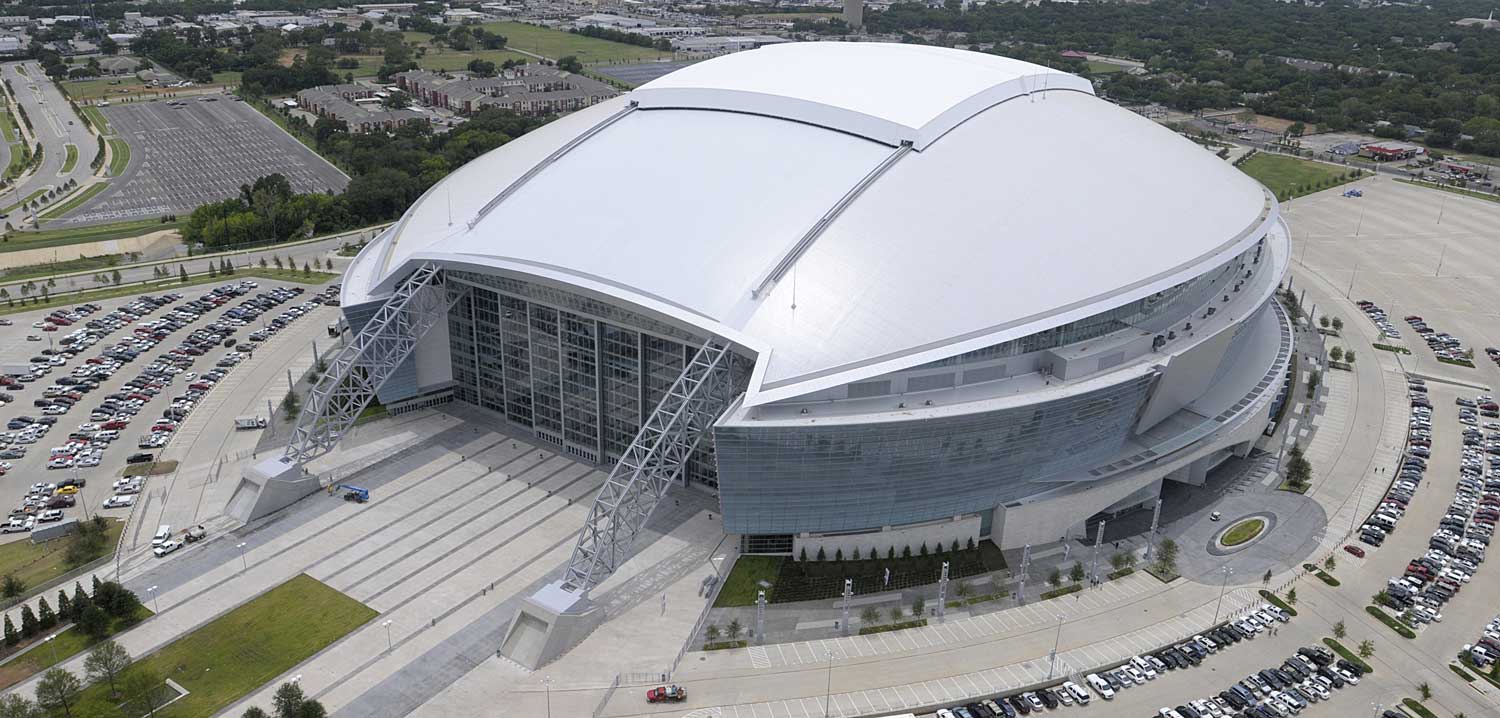 How far do the two main steel arches of the AT&T Stadium span? Stadia